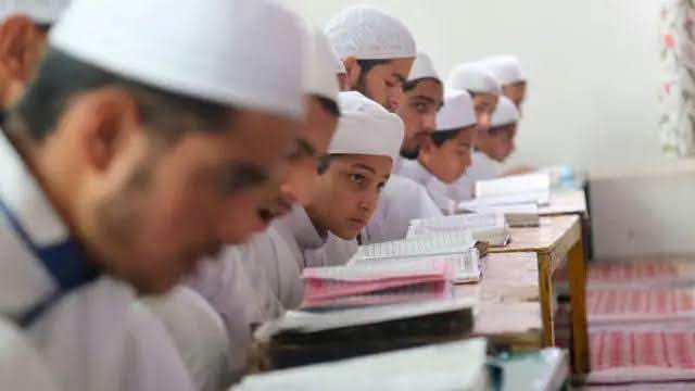 بڑے طلبہ ایک قطار میں بیٹھ کر مطالعہ کرتے ہوئے